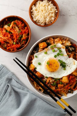 Pirinç ve tavuklu kimçi lahanası. Hafif mermer arka planda beyaz bir kasede servis edilmiş. Üst görünüm.