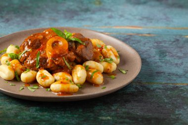 Ossobuco served with gnocchi. Top view, front view.