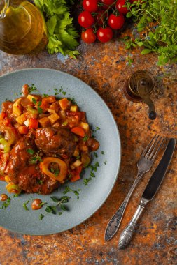 Ossobuco haşlanmış sebzelerle servis edilir. Renkli bir geçmiş. Gri tabak.