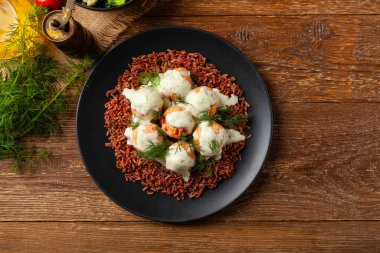 Salmon Meatballs with Red Rice. Wooden background.
