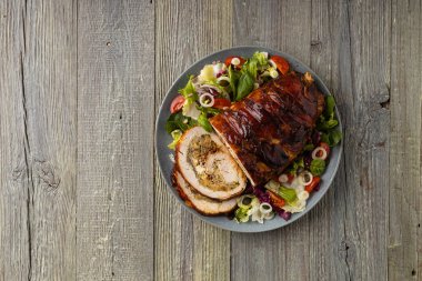 Doldurulmuş hindi göğsü. Taze sebzelerle birlikte bütün olarak kızartılmış. Ahşap arka plan.