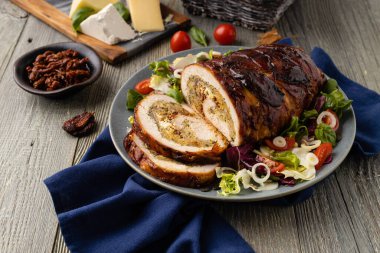 Doldurulmuş hindi göğsü. Taze sebzelerle birlikte bütün olarak kızartılmış. Ahşap arka plan.