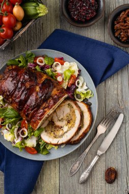 Doldurulmuş hindi göğsü. Taze sebzelerle birlikte bütün olarak kızartılmış. Ahşap arka plan.