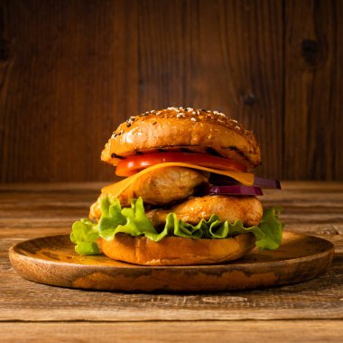 Tavuk çizburger. Tahta, doğal arka plan. Koyu stil.