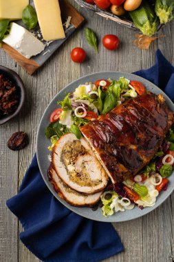 Doldurulmuş hindi göğsü. Taze sebzelerle birlikte bütün olarak kızartılmış. Ahşap arka plan.