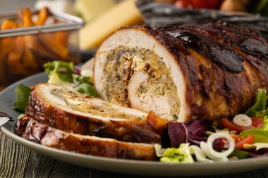 Doldurulmuş hindi göğsü. Taze sebzelerle birlikte bütün olarak kızartılmış. Ahşap arka plan.