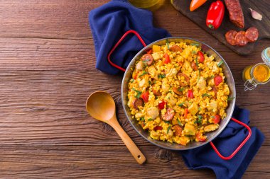 Geleneksel İspanyol Paella 'sı ve tavuk. Ahşap arka plan. Üst görünüm.