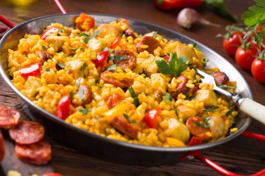 Geleneksel İspanyol Paella 'sı ve tavuk. Ahşap arka plan. Ön görünüm.