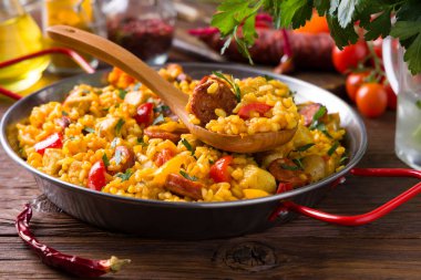 Geleneksel İspanyol Paella 'sı ve tavuk. Ahşap arka plan. Ön görünüm.