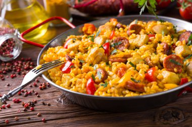 Geleneksel İspanyol Paella 'sı ve tavuk. Ahşap arka plan. Ön görünüm.