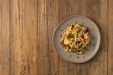 İstiridye soslu tavuklu makarna. Bir tavada hazır. Tabakta servis edilir..