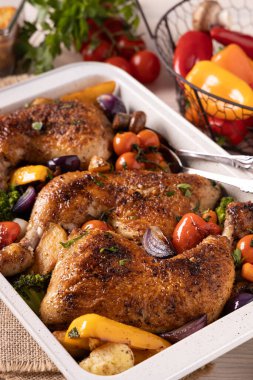 Kızartma tavasında sebzelerle pişirilmiş tavuk budu. Soslu ve patatesli..