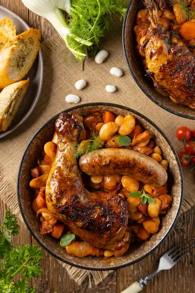 传统的法式一锅菜 鸡肉和白腊肠 卡苏莱天然木制背景 图库图片
