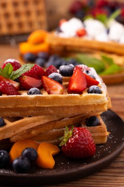 Krem şantili ve taze meyveli nefis ev yapımı waffle. Kağıt tepside ya da tabakta servis edilmiş. Ev yapımı fabrika. Üst veya ön görünüm.