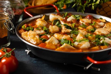 Geleneksel Portekiz balık güveci. Morina yahnisi. Koyu arkaplan.