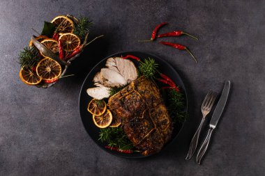 Whole roast pork neck. Christmas decoration. Dark mood.