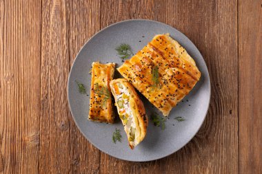 Puf böreğinin içinde sebzeli turta. Tabakta servis ediliyor. Üst veya ön görünüm.