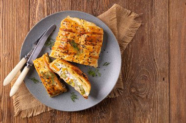 Puf böreğinin içinde sebzeli turta. Tabakta servis ediliyor. Üst veya ön görünüm.