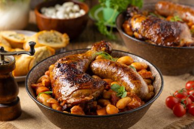 Geleneksel Fransız yemeği, fasulye, tavuk ve beyaz sosis. Cassoulet. Doğal ahşap zemin.