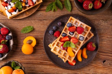 Krem şantili ve taze meyveli nefis ev yapımı waffle. Kağıt tepside ya da tabakta servis edilmiş. Ev yapımı fabrika. Üst veya ön görünüm.