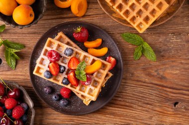 Krem şantili ve taze meyveli nefis ev yapımı waffle. Kağıt tepside ya da tabakta servis edilmiş. Ev yapımı fabrika. Üst veya ön görünüm.