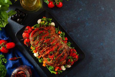 Tam kavrulmuş, domates, zeytin ve domuz boynuyla doldurulmuş. Karanlık arka plan, karanlık ruh hali.