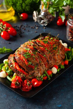 Tam kavrulmuş, domates, zeytin ve domuz boynuyla doldurulmuş. Karanlık arka plan, karanlık ruh hali.