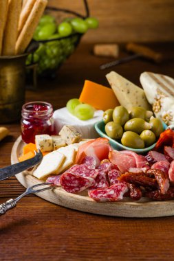 Et ve peynir tahtası. Pek çok ülkeden nefis peynirlerin ve sosislerin karışımı. Eklemek için zeytin, fındık ve sos. Tütsülenmiş ve olgunlaşmış soğuk kesimler, mavi peynirler, baharatlı ve hafif. Üst veya ön görünüm.