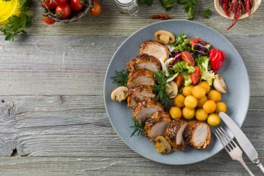 Domuz filetosu, mantar ve biberle servis edilir. Pastırma dilimlerine sarılmış bir bütün olarak. Dilimlenmiş.