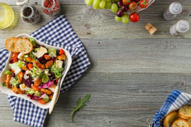 Geleneksel bahardaki İtalyan salatası, kızarmış tavuk, peynirli camembert peyniri, üzüm ve fındık. Kızarmış ekmekle servis edilir. Üst veya ön görünüm. 