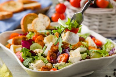 Geleneksel bahardaki İtalyan salatası, kızarmış tavuk, peynirli camembert peyniri, üzüm ve fındık. Kızarmış ekmekle servis edilir. Üst veya ön görünüm. 