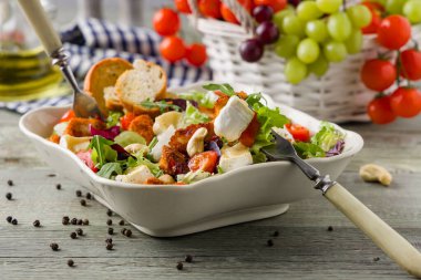 Geleneksel bahardaki İtalyan salatası, kızarmış tavuk, peynirli camembert peyniri, üzüm ve fındık. Kızarmış ekmekle servis edilir. Üst veya ön görünüm. 