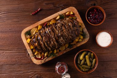 Bütün domuz boynunu kızarttım. Soğan dilimleriyle doldurulmuş. Fırında patatesle servis edilir. Doğal ahşap zemin