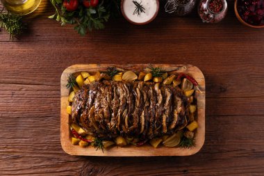 Bütün domuz boynunu kızarttım. Soğan dilimleriyle doldurulmuş. Fırında patatesle servis edilir. Doğal ahşap zemin