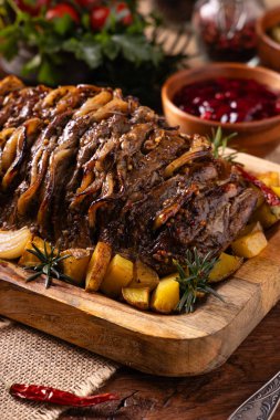 Bütün domuz boynunu kızarttım. Soğan dilimleriyle doldurulmuş. Fırında patatesle servis edilir. Doğal ahşap zemin