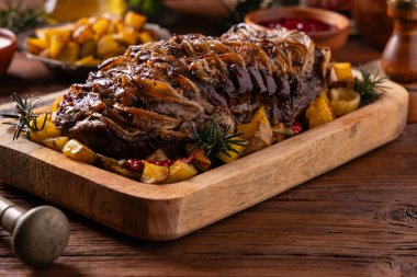 Bütün domuz boynunu kızarttım. Soğan dilimleriyle doldurulmuş. Fırında patatesle servis edilir. Doğal ahşap zemin