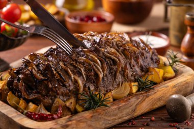 Bütün domuz boynunu kızarttım. Soğan dilimleriyle doldurulmuş. Fırında patatesle servis edilir. Doğal ahşap zemin