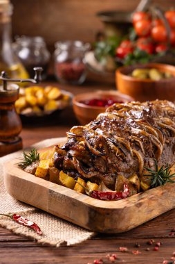 Bütün domuz boynunu kızarttım. Soğan dilimleriyle doldurulmuş. Fırında patatesle servis edilir. Doğal ahşap zemin