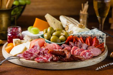Et ve peynir tahtası. Pek çok ülkeden nefis peynirlerin ve sosislerin karışımı. Eklemek için zeytin, fındık ve sos. Tütsülenmiş ve olgunlaşmış soğuk kesimler, mavi peynirler, baharatlı ve hafif. Üst veya ön görünüm.