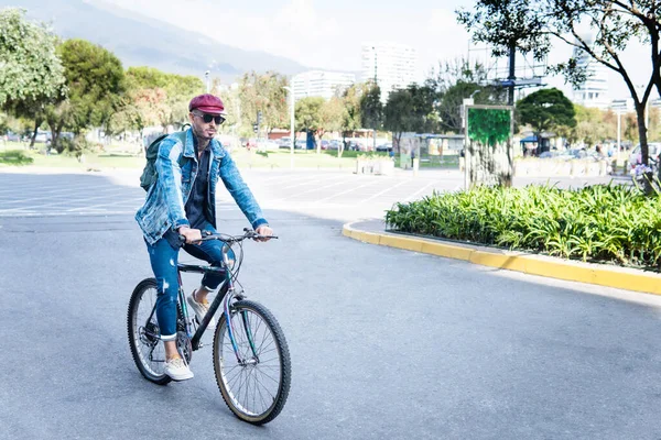 Uomo Latino Jeans Bicicletta Una Città Con Berretto Rosso Occhiali — Foto Stock