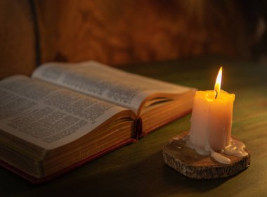 bible lit with a candle religion and message concept