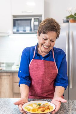 Granny smiling serving soup. High quality photo