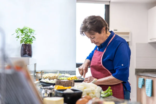 Granny cooking at the kitchen counter. High quality photo