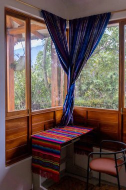 Bir kır evinin penceresinin yanındaki küçük bir masanın dikey fotoğrafı. Yüksek kalite fotoğraf