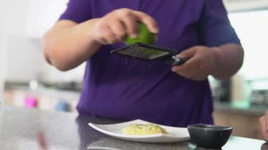 Evinin mutfağında tatlı yerken limon yiyen tanınmamış bir kadının elleri.