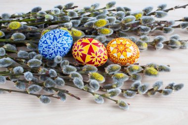 Traditional Ukrainian Easter eggs and blooming willow twigs on a wooden background. Easter Palm Sunday. clipart