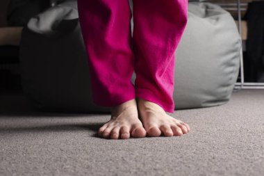 Yerde duran çıplak ayaklı bir kız. İnsan ayağı