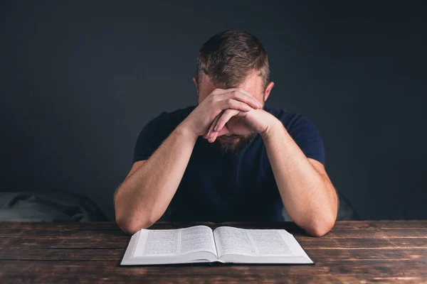 Man Prays Folded Hands Open Holy Bible Table Young Man — Stock Photo, Image