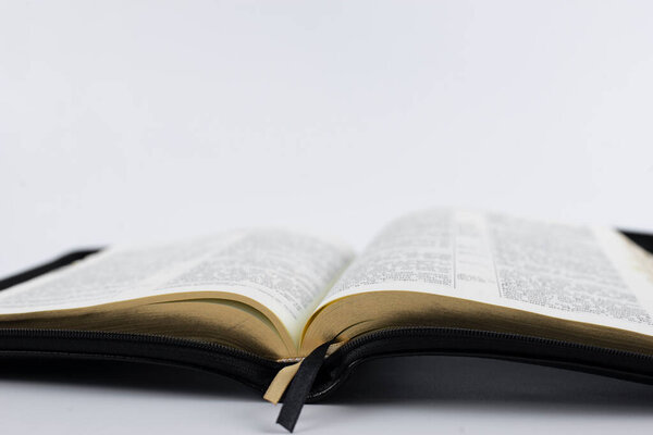 An open Bible on the table. On a white background. Writing