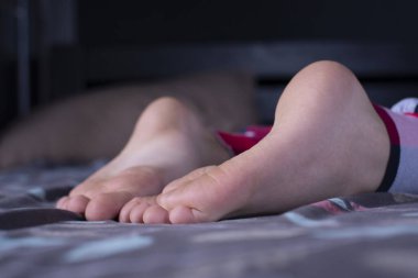Çıplak ayaklı bir çocuk. Ayak. Yatakta pijamalı çocuklar.